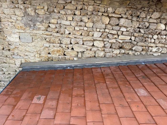 Couverture en tuiles neuve et solin contre un mur en pierre